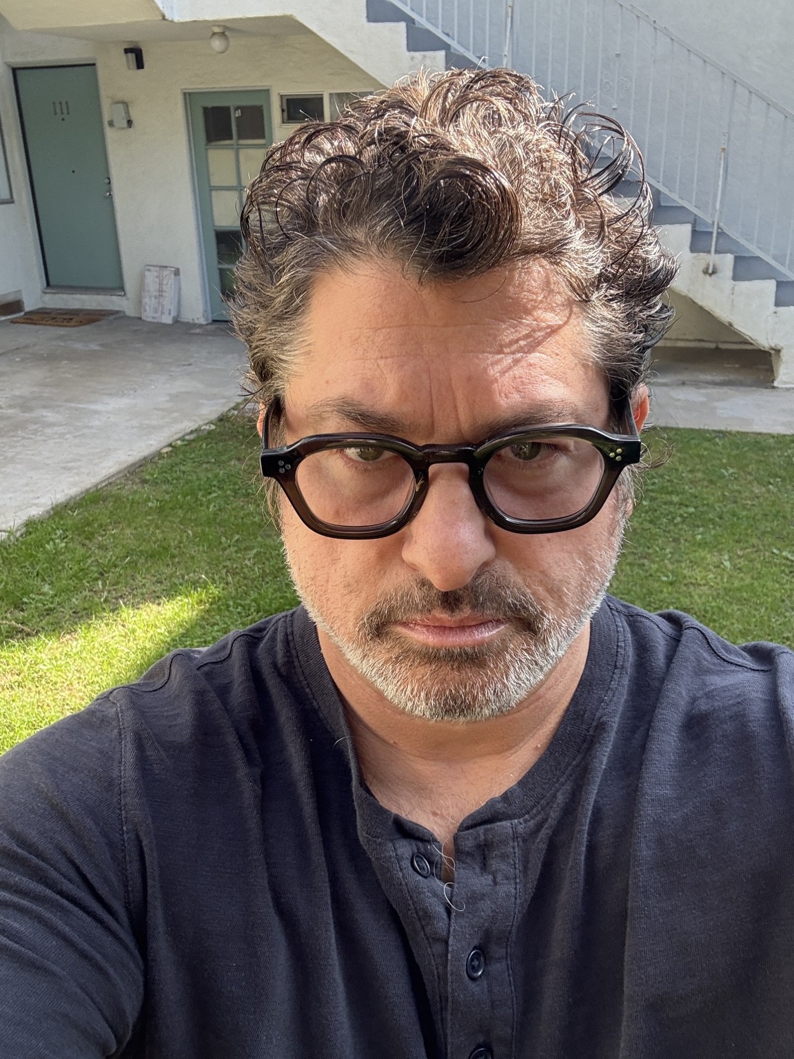 Current portrait of Ronan David wearing glasses outdoors.